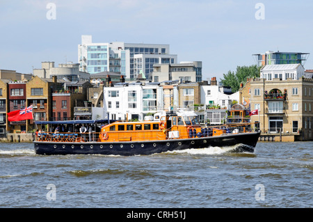 Motor launch Havengore on River Thames passing The Grapes riverside Inn at Limehouse assumed private hospitality charter Tower Hamlets East London UK Stock Photo