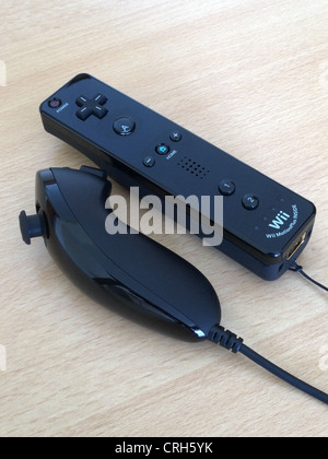 Nintendo Wii Black Remote Controller and Nunchuck on a Wooden Background Stock Photo