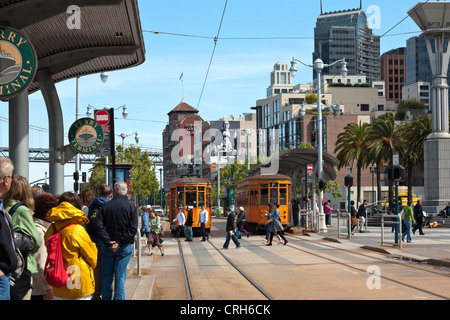 People waiting for vintage orange trolleys at the intersection of Market Street and the Embarcadero, San Francisco, California. Stock Photo