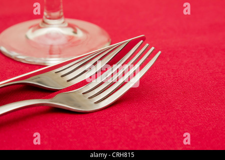 Knife fork and glass on red tablecloth Stock Photo