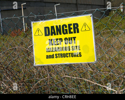 Danger Keep Out sign outside a derelict factory complex Stock Photo