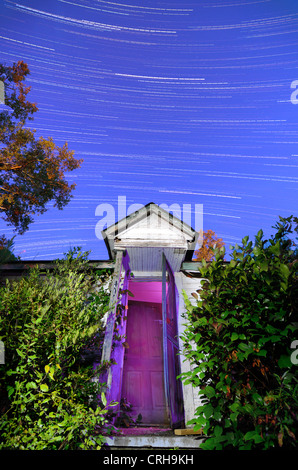 abandoned home front door under star trails Stock Photo