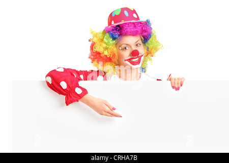 A female clown with happy joyful expression on her face posing behind a white panel isolated on white background Stock Photo