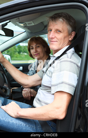 Mature male and woman sitting in land vehicle and smiling Stock Photo