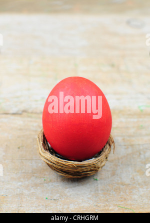 Red easter egg in nest on wooden background Stock Photo