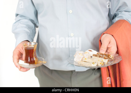 Young man serving traditional turkish chai and sweets Stock Photo
