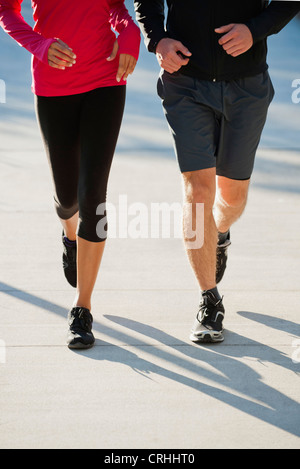 Couple jogging side by side, low section Stock Photo