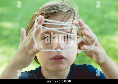Boy playing cat's cradle Stock Photo