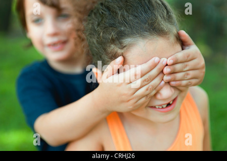 Boy covering girl's eyes Stock Photo