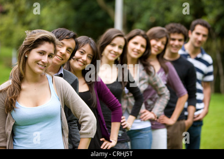 group of students standing one behind another, hands on hips, smiling Stock Photo