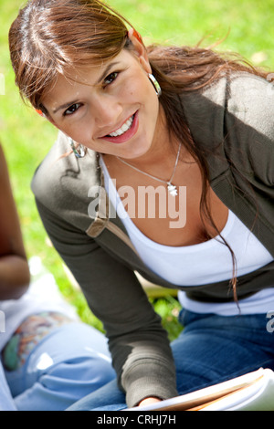 young beautiful college student sitting outdoors with notebook Stock Photo