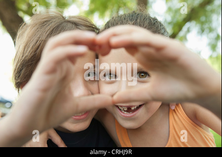 Boy and girl making heart shape with hands Stock Photo