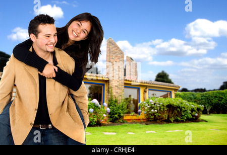 young couple having fun at home with their house in the background Stock Photo