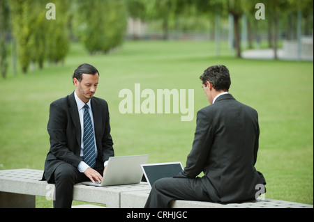 Businessmen using laptop computers outdoors Stock Photo