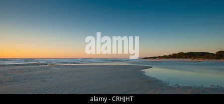 Sun rising over sandy beach Stock Photo - Alamy