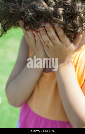 Girl covering face with hands Stock Photo
