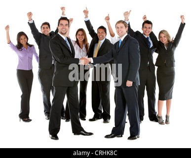 two businessmen shaking hands, with a group of young business people cheering behind Stock Photo
