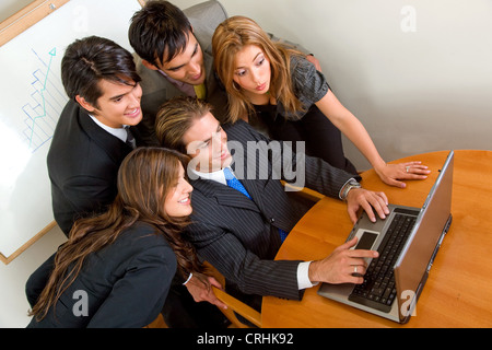 young team of business people at a laptop, looking at the computer Stock Photo
