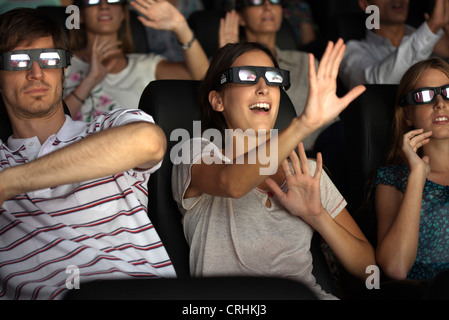 Audience enjoying 3-D movie in theater Stock Photo