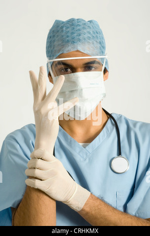 Surgeon putting on disposable latex gloves Stock Photo