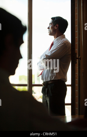 Silhouette of businessman standing by window Stock Photo