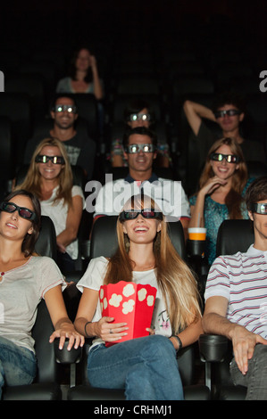 Audience wearing 3-D glasses in movie theater Stock Photo