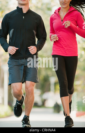 Couple jogging side by side, cropped Stock Photo