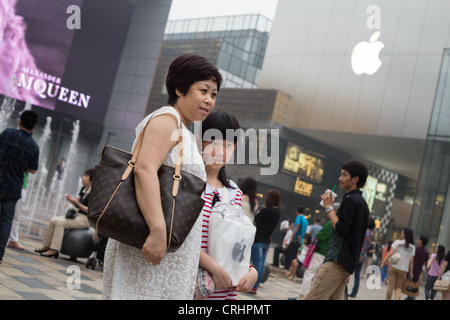Two Chinese ladies carry Louis Vuitton handbags at Beijing Scitech