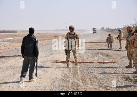 British soldiers and afghan policeman prepare to search a vehicle destined for the Taliban stronghold at Marjah, Afghanistan. Stock Photo