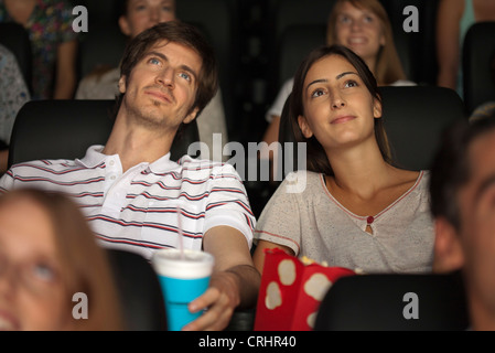 Couple enjoying movie in theater Stock Photo