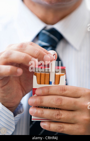 Removing rolled euro from cigarette pack Stock Photo
