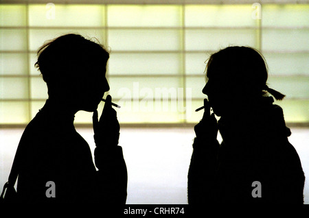 Silhouettes of two girls smoking Stock Photo