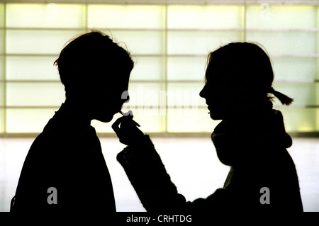 Silhouettes of two girls with a cigarette Stock Photo