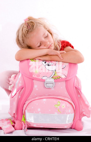 school girl sleeping on school bag Stock Photo