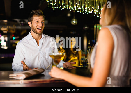 Woman talking to bartender at bar Stock Photo