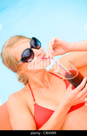 young attractive woman on airbed in swimming pool Stock Photo