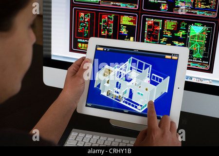 Architect using iPad CAD Computer Aided Design application to model 3D layout design of new house Stock Photo