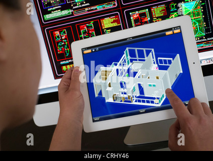 Architect using iPad CAD Computer Aided Design application to model 3D layout design of new house Stock Photo