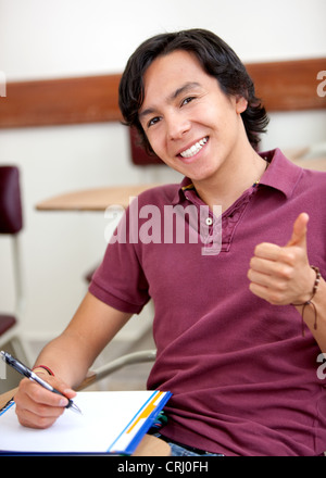 university student making notes on a ring binder and thumbs up with a smile Stock Photo