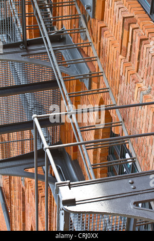 Steel emergency exit ladder on renovated factory building with brick wall Stock Photo