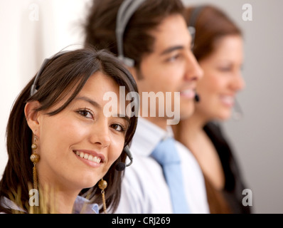 3 smiling young people with headsets Stock Photo