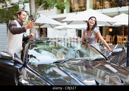 Couple climbing out of car Stock Photo