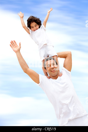 father and son having fun, son standing on his father's shoulders Stock Photo