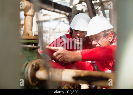 Workers examining equipment on site Stock Photo