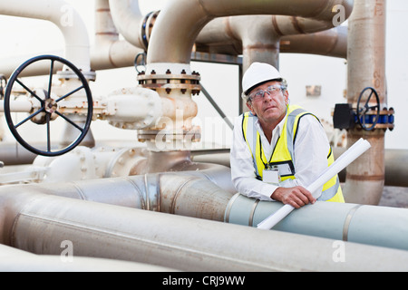 Worker on pipes at chemical plant Stock Photo