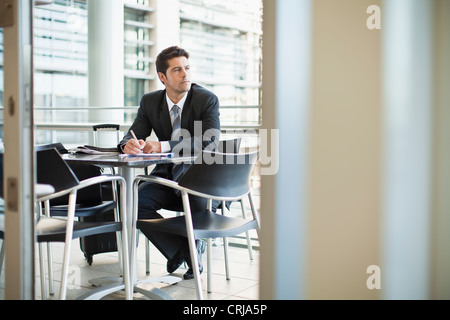 Businessman making notes in cafe Stock Photo
