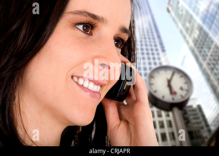 girl on the phone in the city, with hour in background Stock Photo