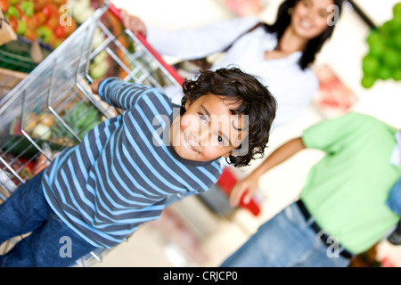 boy and his family shopping at the supermarket Stock Photo