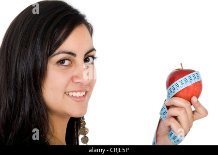 young woman holding a red apple with a measuring tape wrapped around Stock Photo