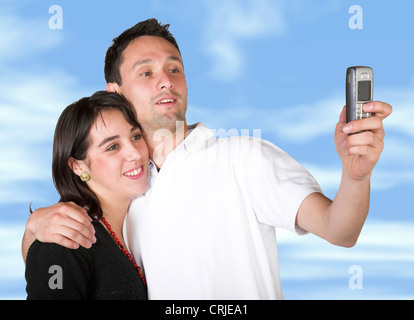 couple taking a pic with cell phone with sky in the background Stock Photo